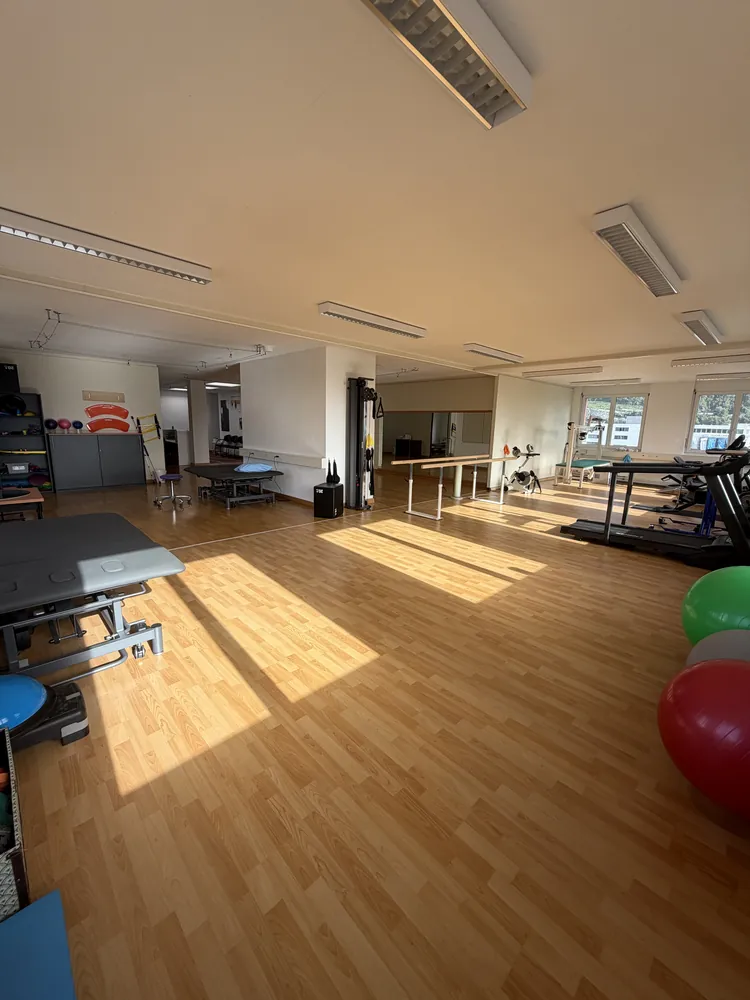 Grande salle de rééducation lumineuse avec tables et appareils