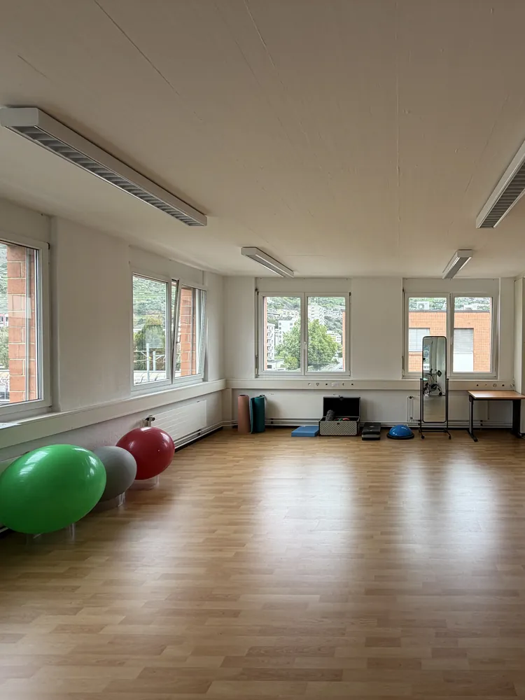 Salle d'exercices avec ballons et grandes fenêtres